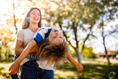 Happy mother and son having fun during spring day in nature. Copy space.